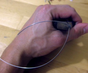 Hold the wire with the needlenose pliers and bend the wire to form a 90 degre bend.